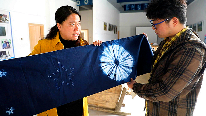 马丽华向记者展示洪江村传统的扎染技艺-a