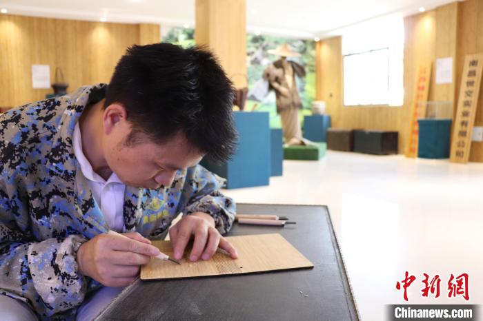 图为陈艳华正在楠竹上雕刻。 刘玉洁 摄
